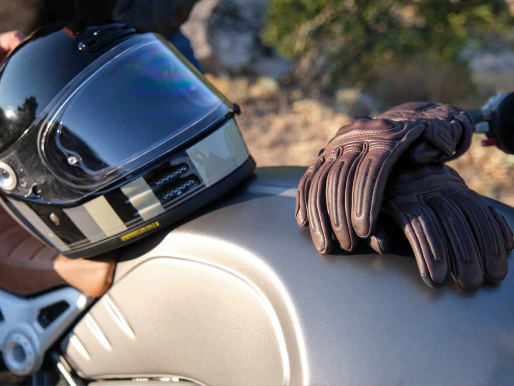 A motorcycle helmet and gloves sitting on top of a motorcycle.